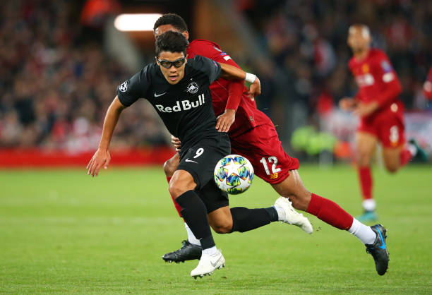 Hwang Hee-chan of Red Bull Salzburg holds off a challenge from Joe Gomez of Liverpool during the UEFA Champions League group E match between Liverpool FC and RB Salzburg at Anfield. 